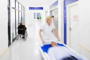 Uni Klinik Foto eines Ganges, Rollstuhl und Krankenschwester