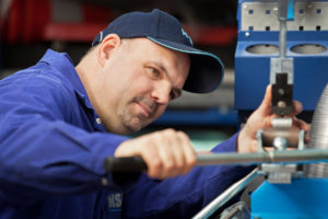 Handwerker des Industrieunternehmens bedient eine Maschine