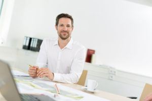 Junger Mann am Schreibtisch, im Büro.