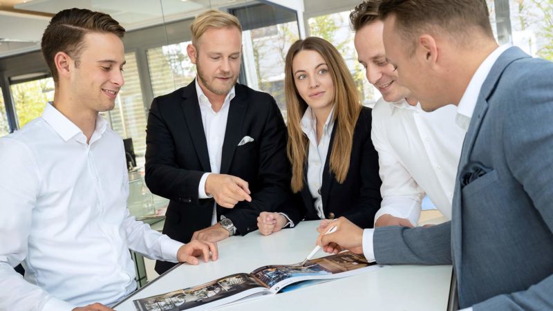 Business Frau und junge Männer im Gespräch an einem Tisch