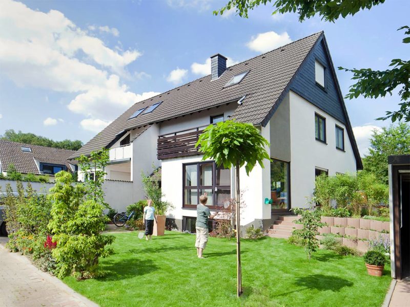 Einfamilienhaus und 2 Kinder auf dem Rasen, Fotograf Dirk Baumbach.