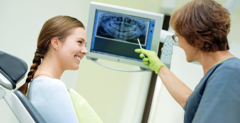 Gespräch über Röntgenbild in Zahnarzt Praxis. Medizin Foto.