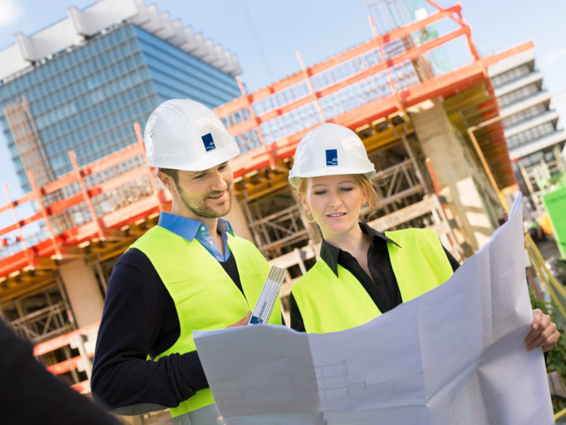 Ingenieure mit Bauplan auf der Baustelle der Uni Klinik Köln.