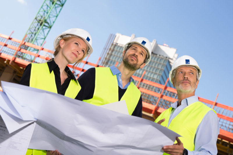 Baustellen Fotografie. Ingenieure mit Bauplan.