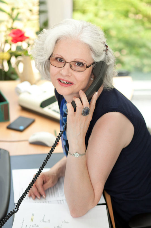 Beispiel Foto einer Mitarbeiterin am Telefon.