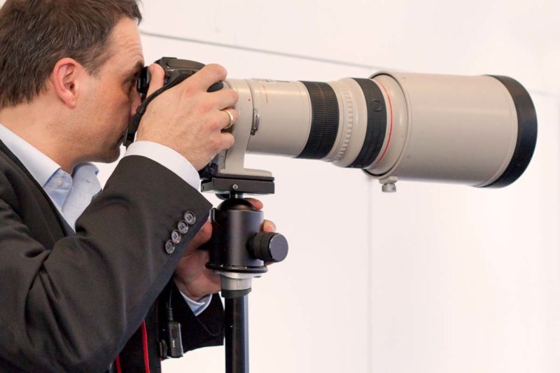 Pressefotograf mit Kamera und Teleobjektiv
