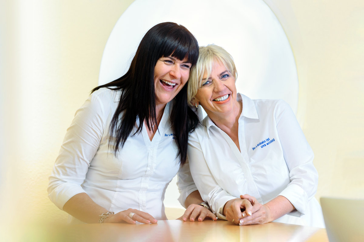 Zwei Zahnärztinen und ein lachendes Team Foto