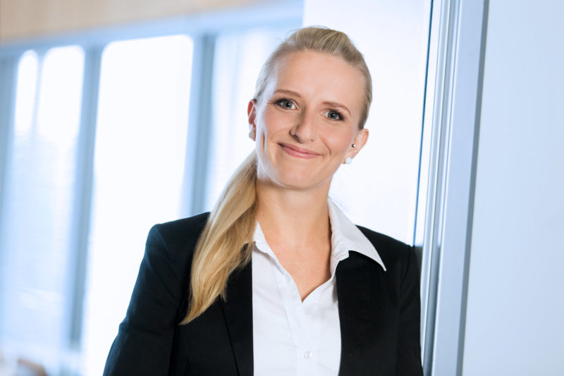 Junge Business Frau lehnt am Türrahmen. Foto im Büro