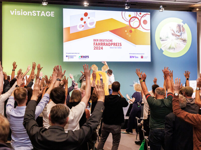 Auf der VisionSTAGE ist die Stimmung groß. Alle Gäste feiern den Gewinner des Deutschen Fahrradpreises. Ein Event- und Pressefoto des Köln Eventfotografen.