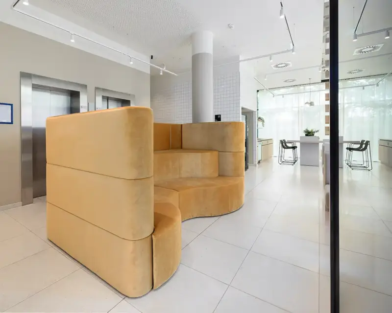 Neues Intereieur im Hotel. In der Lobby gibt es einen großen Lounge Bereich mit gemütlicher Couch. Eine Hotelfotografie des Fotografen in Köln.