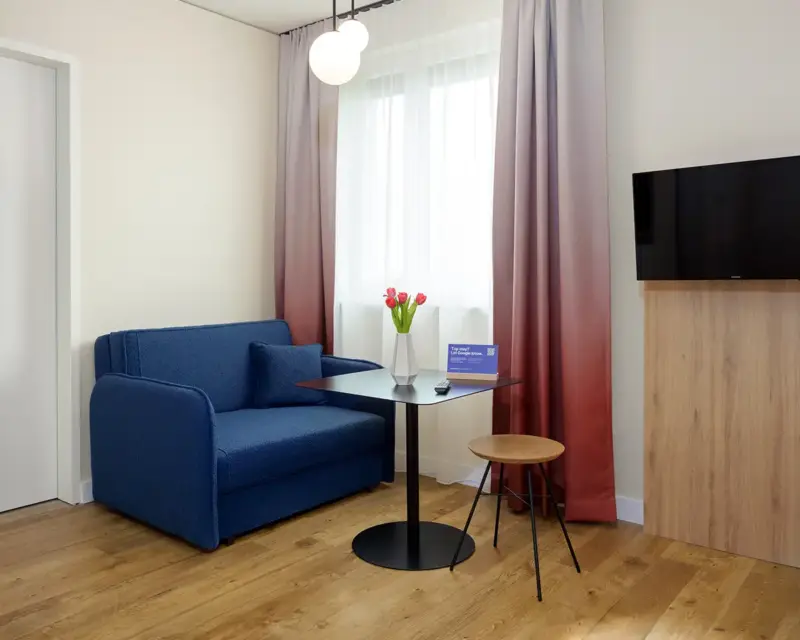 Kleine Couch mit Tisch und Hocker. Ein Hotelzimmer Foto des Hotelfotografen im Ruhrgebiet, Dirk Baumbach.