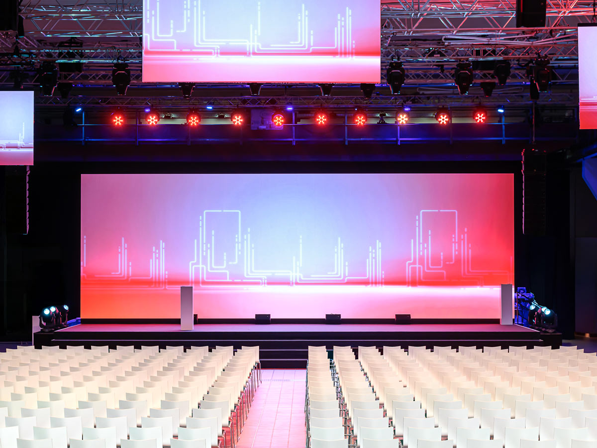 firmen-event-location-essen Der Aufbau für das Firmen Event in Essen ist beendet. Stuhlreihe mit großer LED Wand.