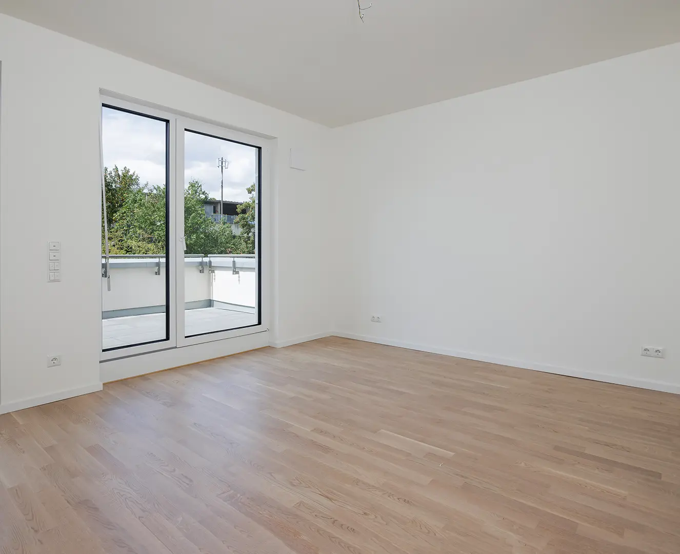 Haus Bau Dokumentation Dokumentation des Baufortschritts. Sie sehen ein Foto nach der Fertigstellung. Ein großer Raum mit Vinylboden und Balkon.